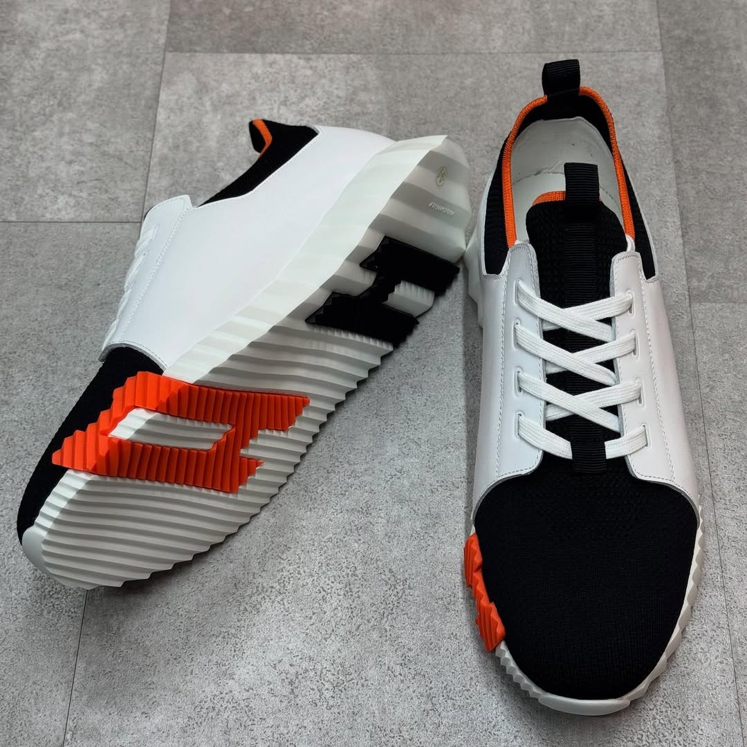 Hermés Depart Slip-On Sneaker in White Knit and Calfskin with a Black and Orange Rubber Sole